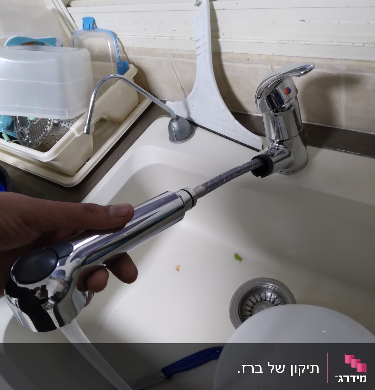 ברז מטבח עם צינור נשלף ביד אדם